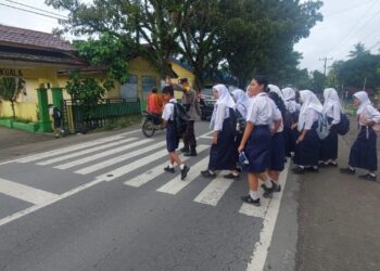 Peduli Keselamatan Siswa, Bhabinkamtibmas Polsek Kuala Turun Langsung Atur Lalu Lintas Pagi Hari